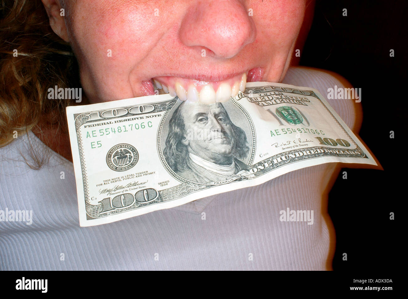 Frau mit 100-Dollar-Rechnung Hinweis geballt in den Zähnen Stockfoto