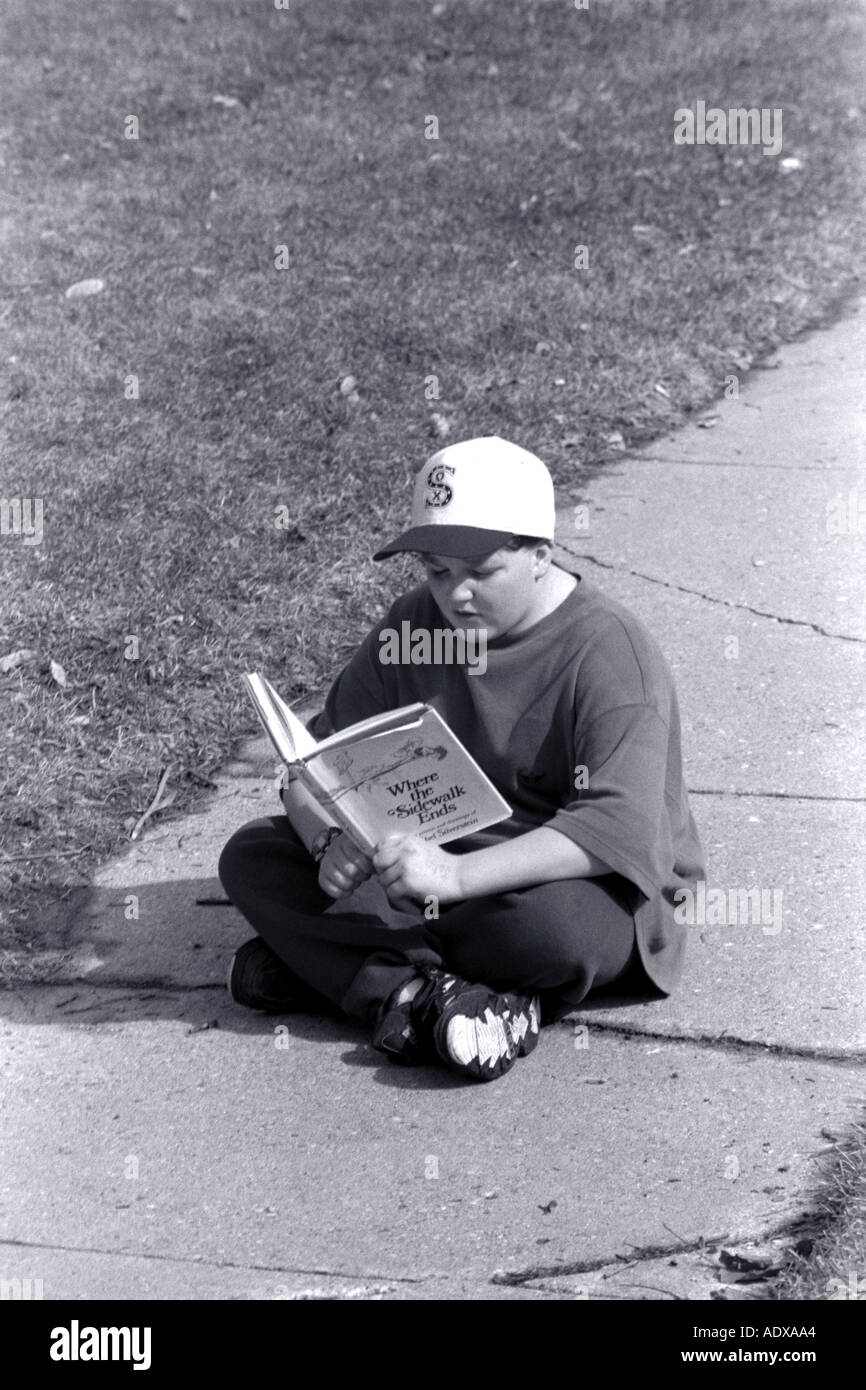 Jungen lesen außerhalb Stockfoto