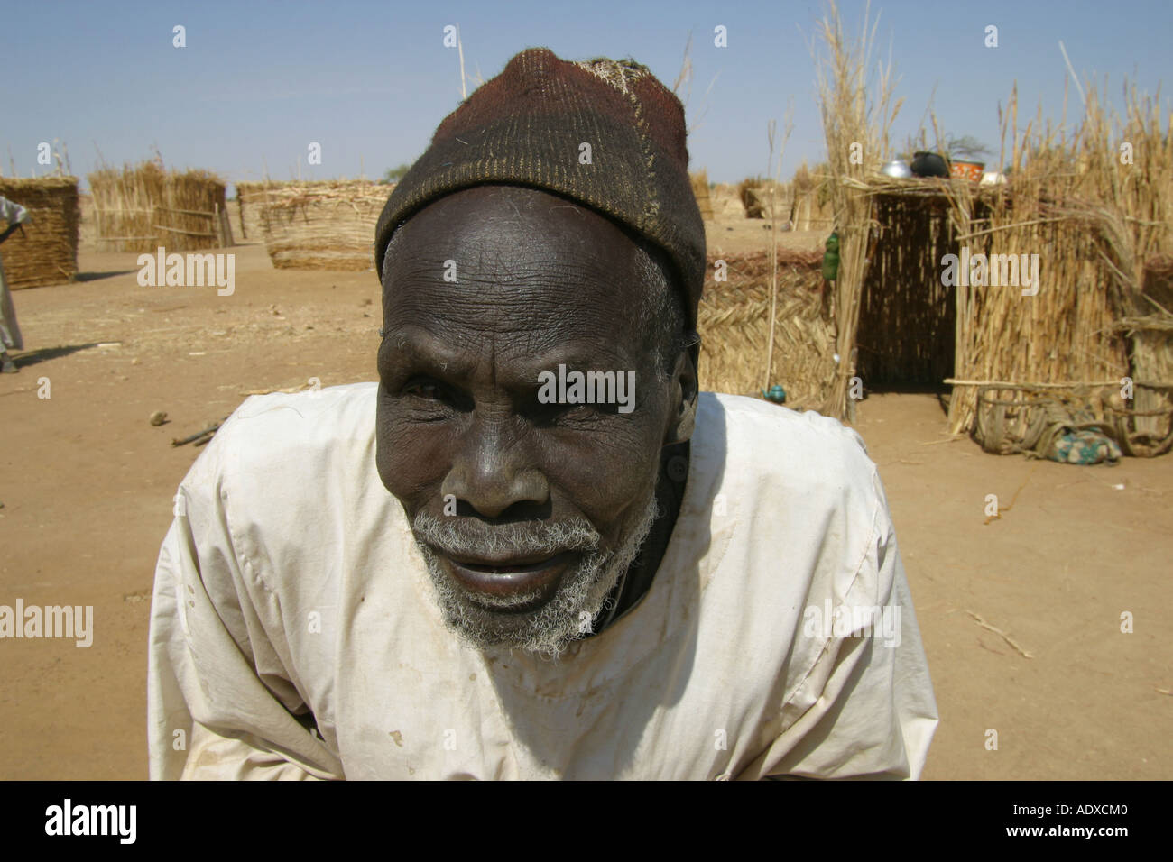 Sudanesische Greis in Flüchtlingslager im Tschad, wo er ein klein und Simpel Hut von Grass baute Stockfoto