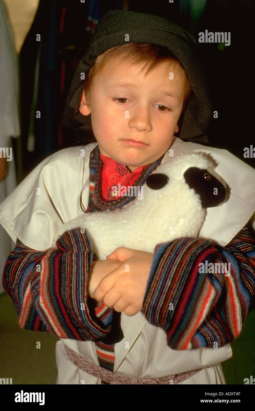 Junge Hirte Alter 7 umarmt sein Lamm am Krippenspiel. Western Springs, Illinois USA Stockfoto