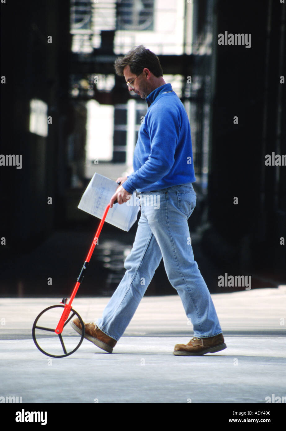 Arbeiter Chicago Illinois Mann verwenden Trundle Rad, um Abstand halten Blaupausen Spaziergang Straße hinunter messen Stockfoto