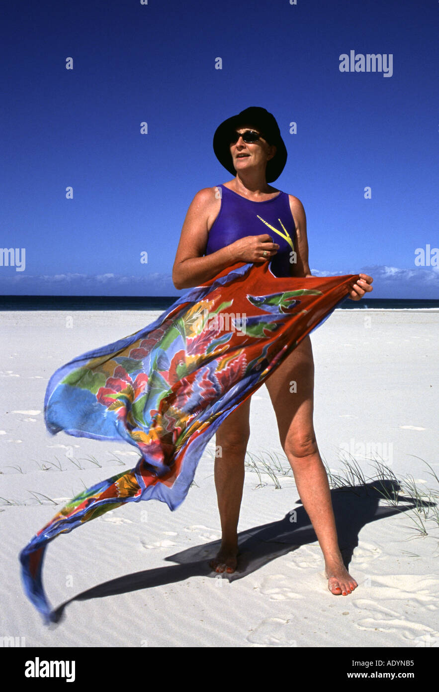 Farbfoto einer Frau, die einen Sarong am Strand hält, Kirra Beach, Gold Coast, Queensland, Australien Stockfoto