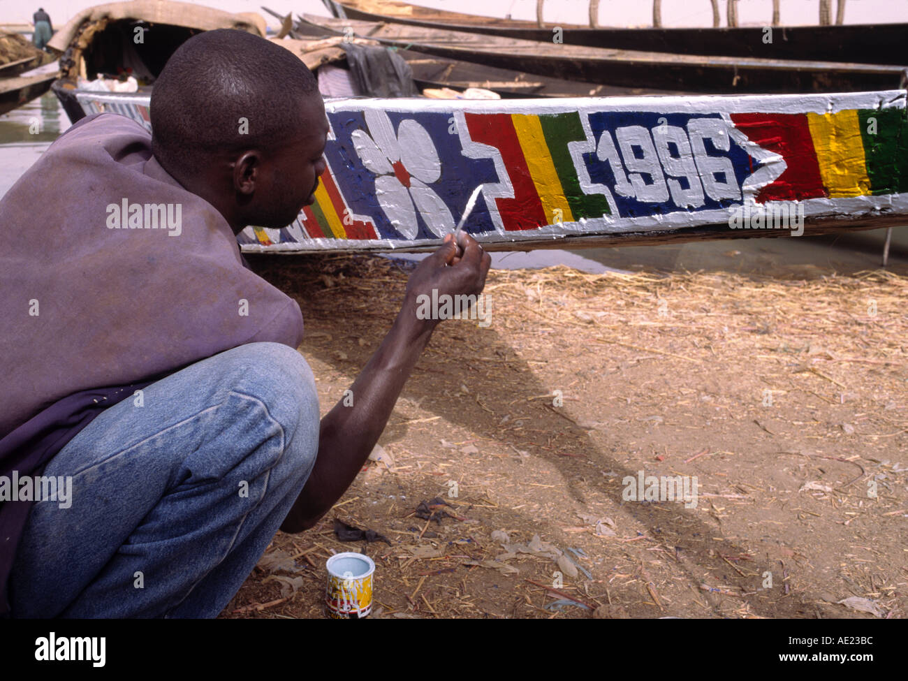 Mann, die Malerei seiner Piroge an den Ufern des Flusses Niger, Mopti, Mali Stockfoto