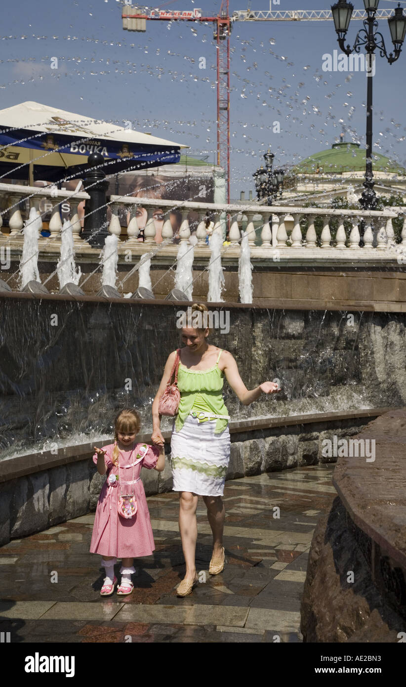 Kind und Mutter spielen unter den Brunnen im Alexander-Garten in der Nähe von Manezhnaya Square Moskau Russland Stockfoto