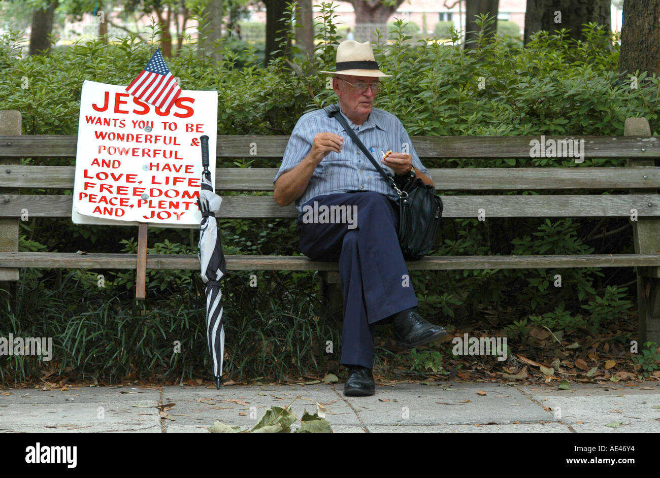 Religiöse Bill Board Mann sitzen auf Bank in Forsyth Park Savannah Georgia USA Stockfoto