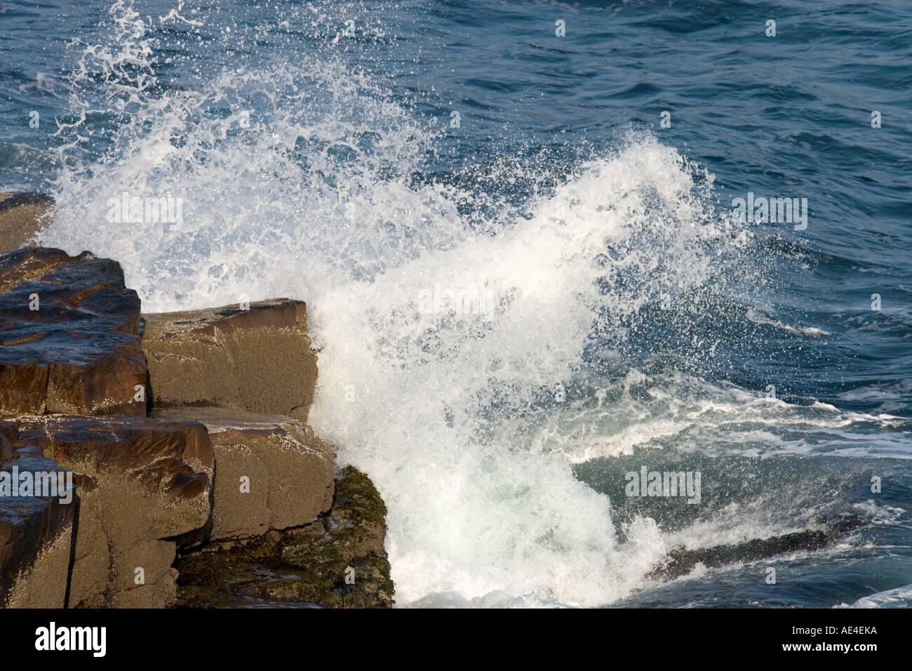 Welle, die entlang der Küste Klippen stürzt ab Stockfoto