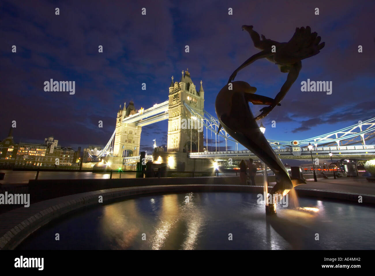 Tower Bridge beleuchtet in der Nacht mit Magd und Dolphin Statue, London Stockfoto
