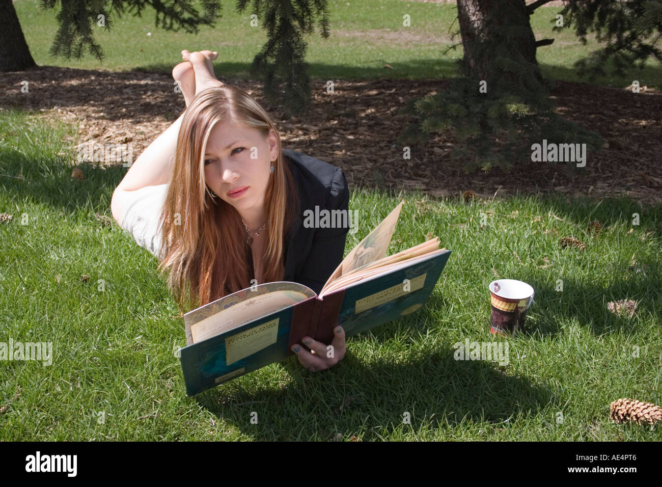 Mädchen-Lesebuch im Park in Calgary Alberta Kanada Stockfoto