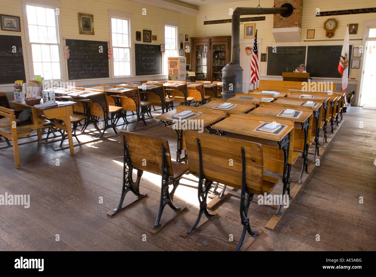 Klassenzimmer in Nachbildung des 1800 s Ära Einzimmer Schulhaus mit Childrens Schreibtische Tafeln und Holz Herd Old Town Sacramento Stockfoto