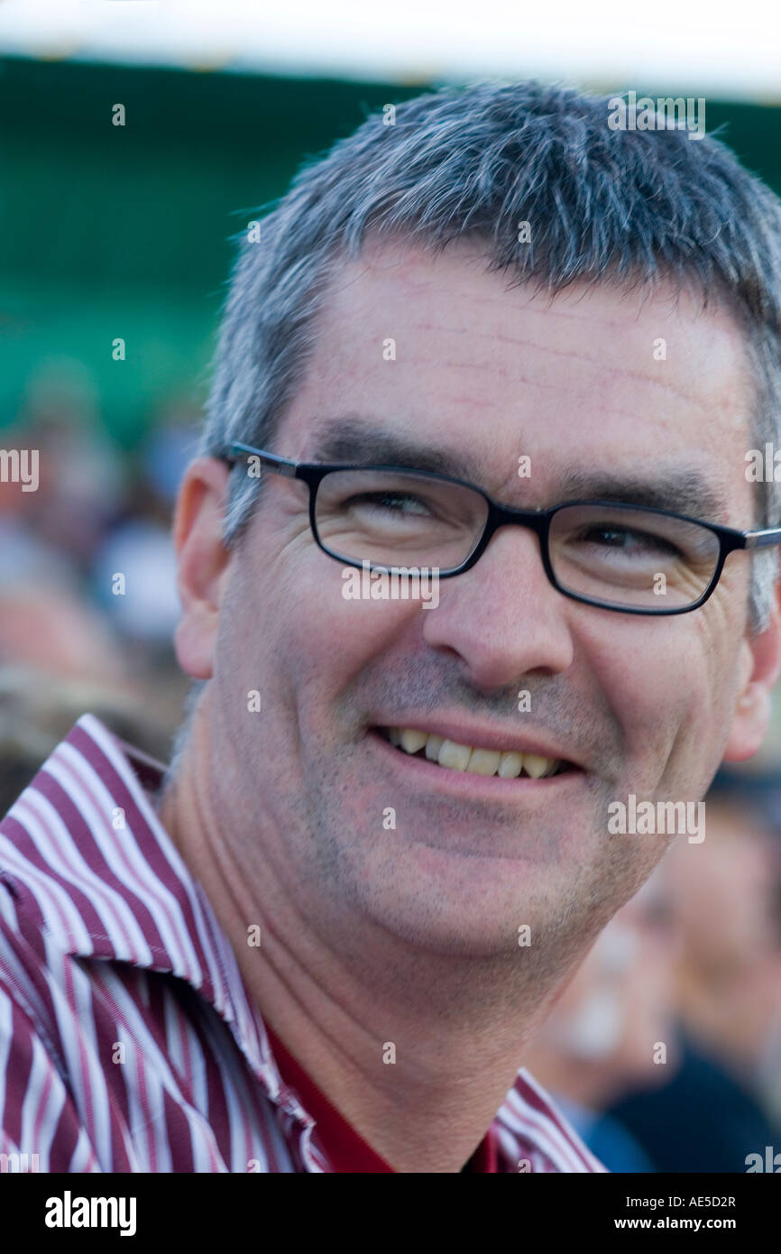 Porträt eines Mannes im Alter von 41 Jahren mit ergrauten Haar mit Brille lächelnd und Blick auf die Seite Stockfoto