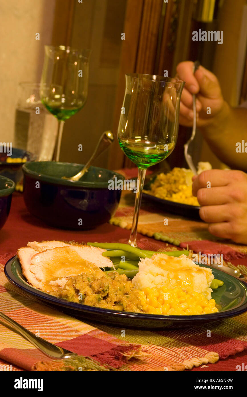 Sitzen am Esstisch zu Thanksgiving-Essen mit der Türkei gestampften Kartoffeln Soße Füllung und grüne Bohnen Stockfoto