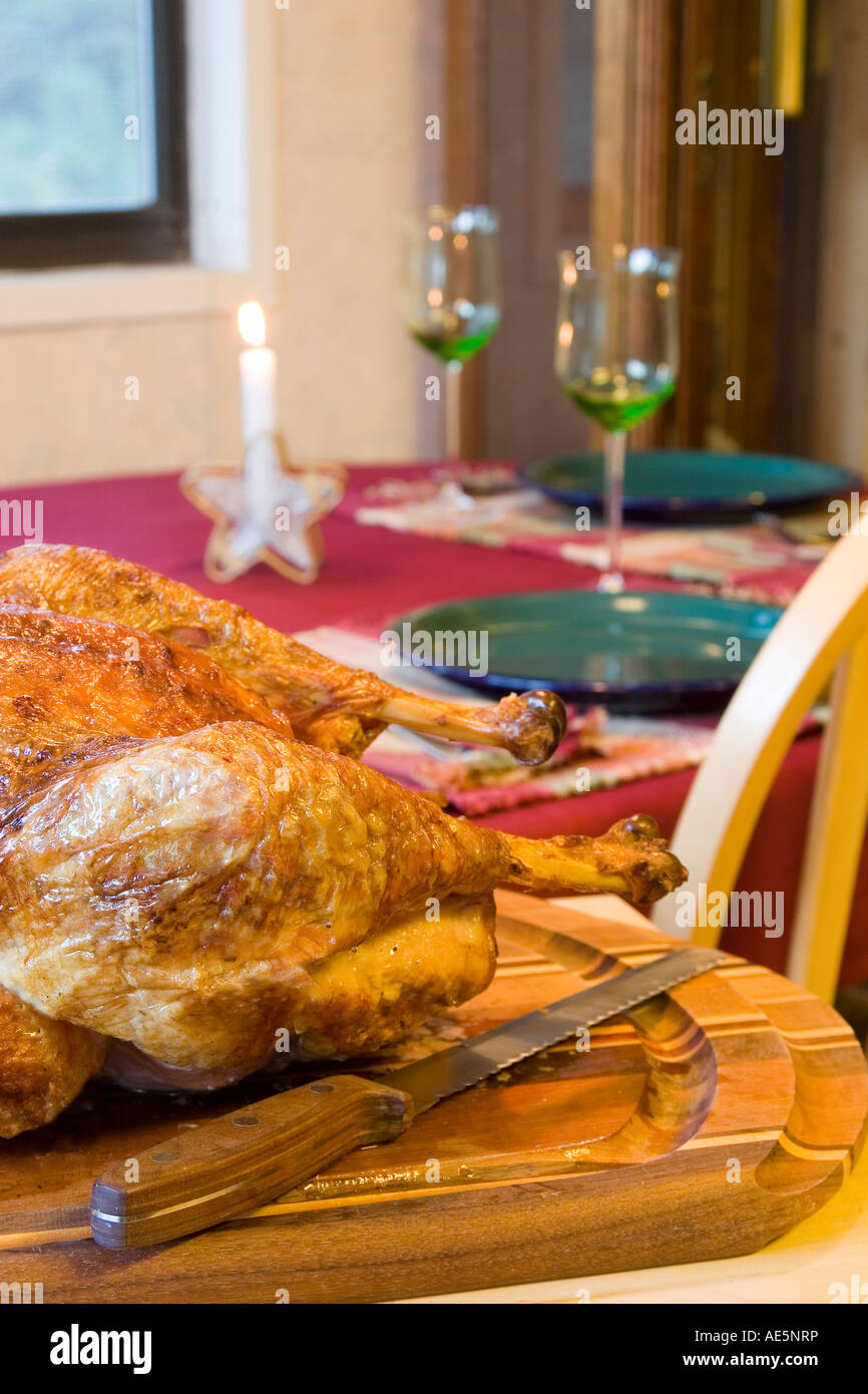 Thanksgiving-Truthahn mit Messer auf ein Schneidebrett neben Tisch mit festliche Gedecke Stockfoto