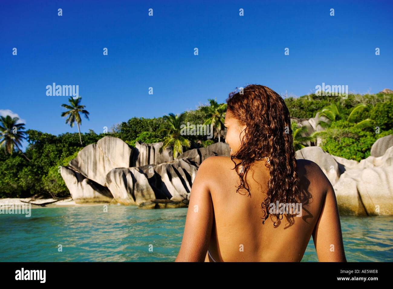 Frau entspannt auf Boot Granitfelsen im Hintergrund Anse Source d Argent Strand La Digue Island-Seychellen Stockfoto