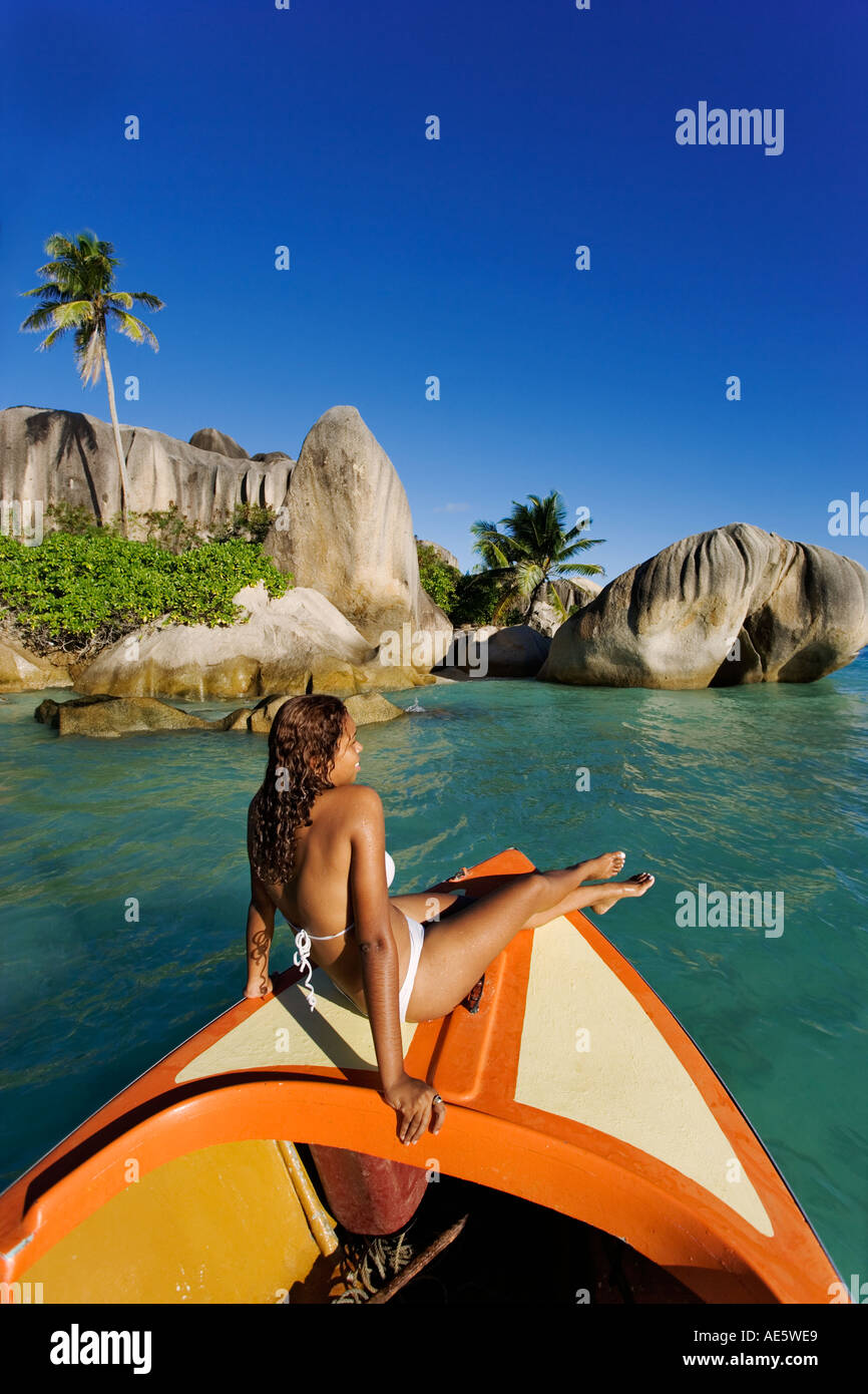 Frau entspannt auf Boot mit Granitfelsen im Hintergrund Anse Source d Argent Strand La Digue Island-Seychellen Stockfoto