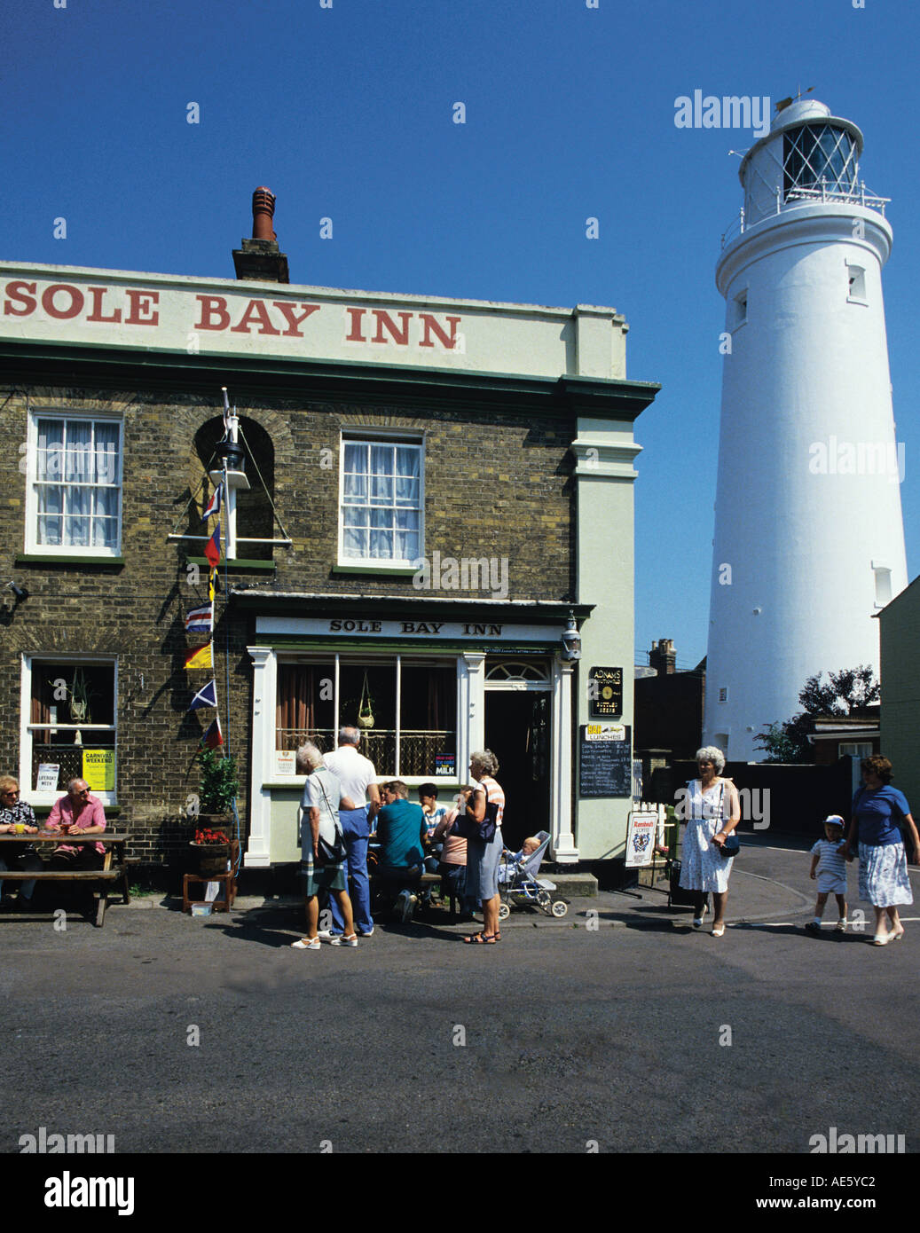Besucher im Sommer genießen Sie die Sonne vor lokalen Pub ist der Leuchtturm im Sommer nachmittags und die meisten Wochenenden geöffnet Stockfoto