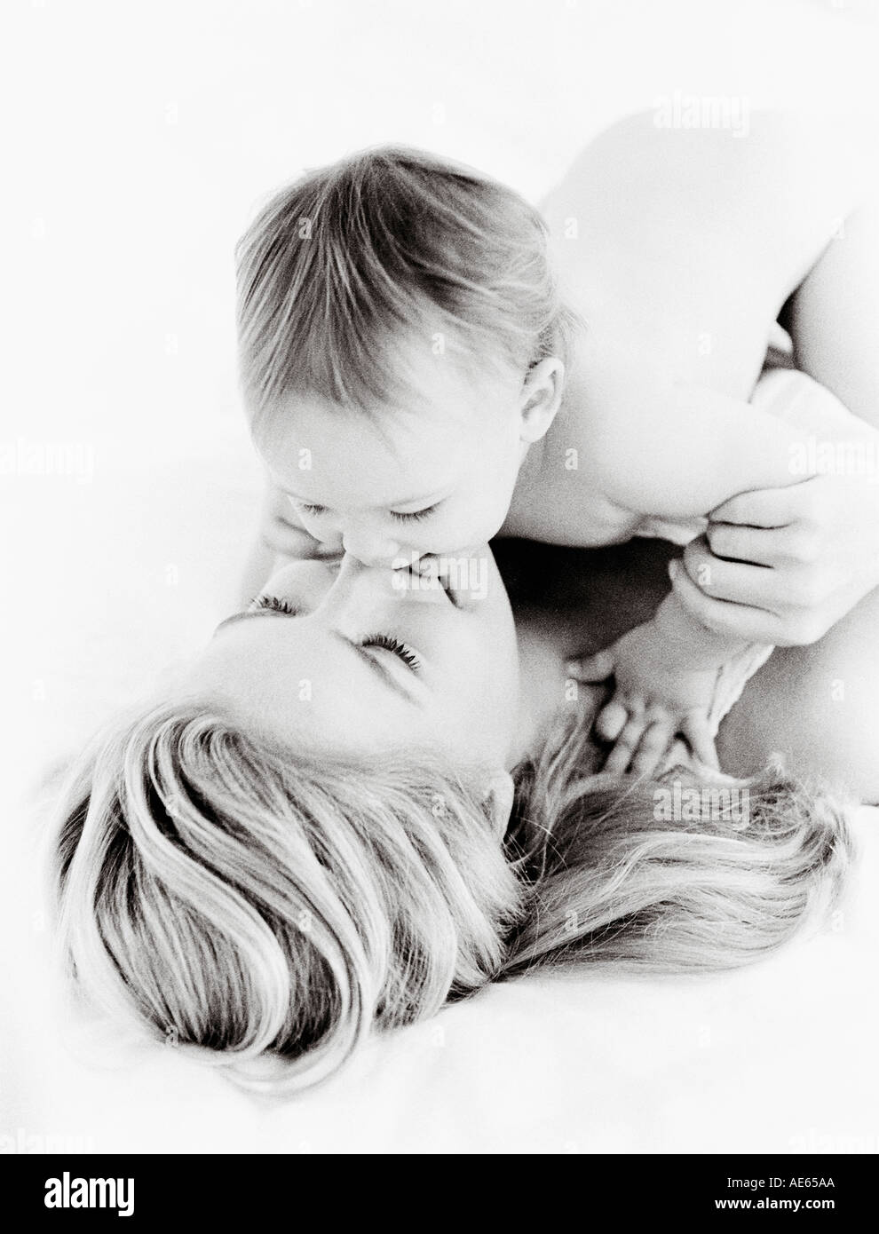 Mama und Baby küssen auf Bett Stockfoto