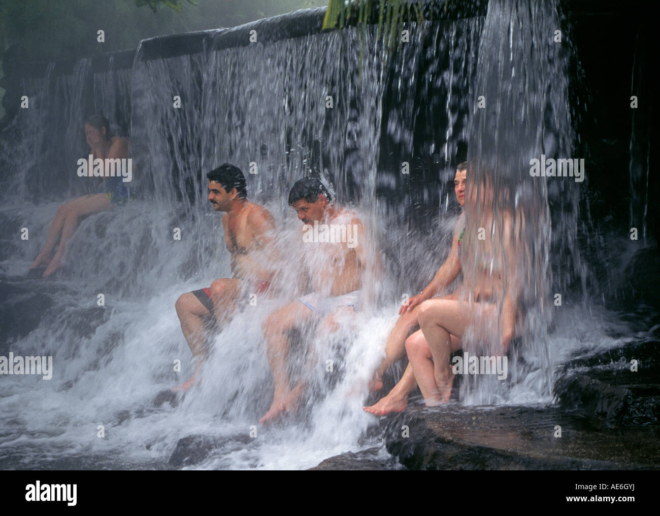 Lokale Costa Ricans genießen Sie ein heißes Bad und ein Dampfbad in einem Wasserfall in den heißen Quellen im Tabacon Hot Springs in der Nähe von Vulkan Arenal, Costa Rica. Stockfoto