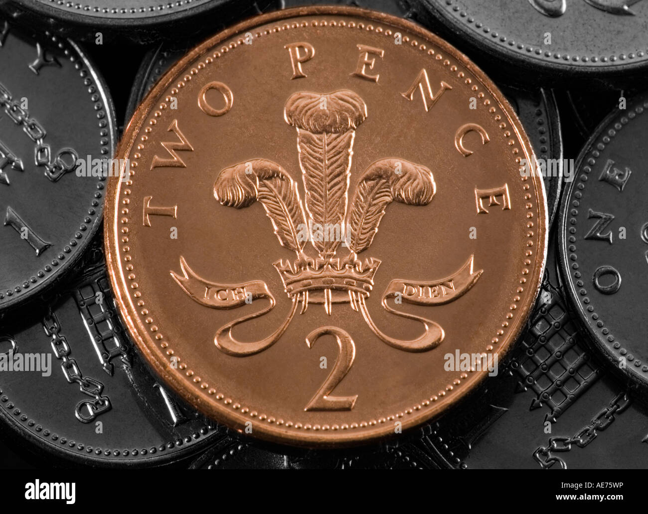 Eine zwei Pence-Münze in Farbe mit anderen zwei und eins Pence Münzen in Monochrom Stockfoto