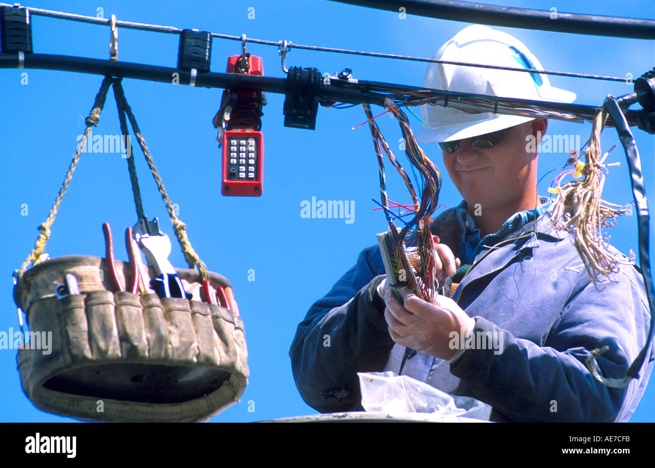 Telefon Lineman tragen Schutzkleidung und Handschuhe bei der Festsetzung der Telefonleitung Stockfoto