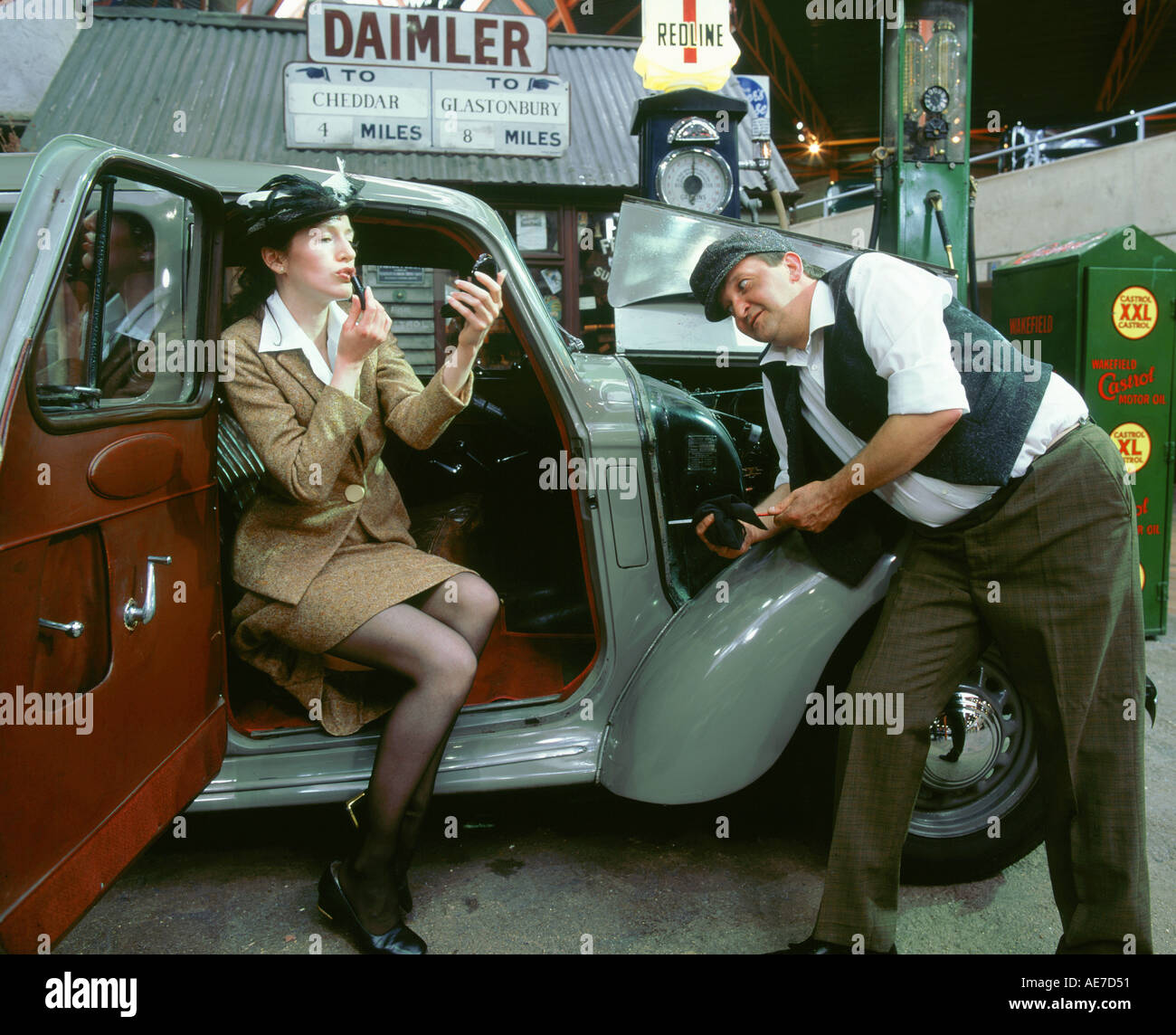 Mechaniker mit Dame Fahrer tun ihr Make-up 1930 s Hillman Minx Stockfoto