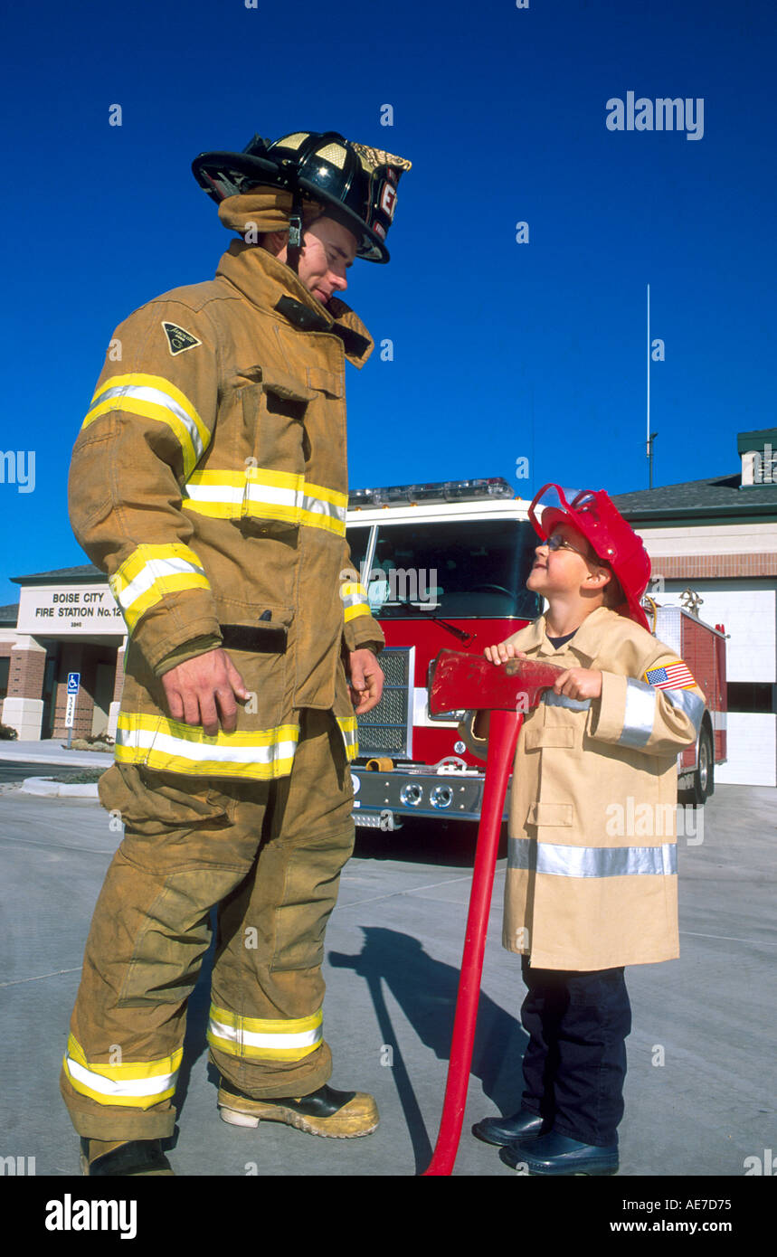 Feuerwehrmann besucht mit kleiner Junge gekleidet in Feuerwehrmann suite Stockfoto