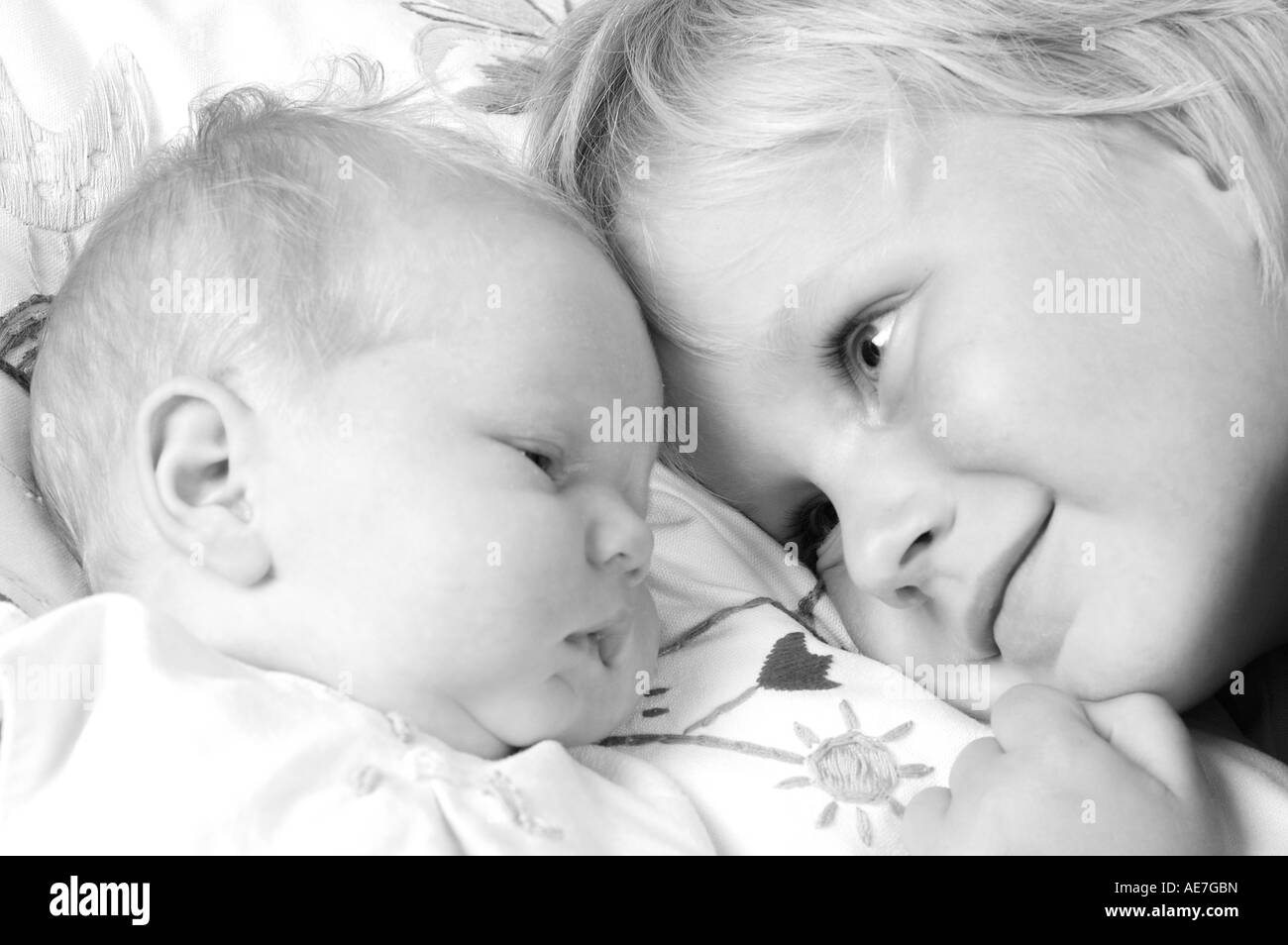 Bild eines älteren Bruders suchen liebevoll auf seine kleine Schwester Stockfoto