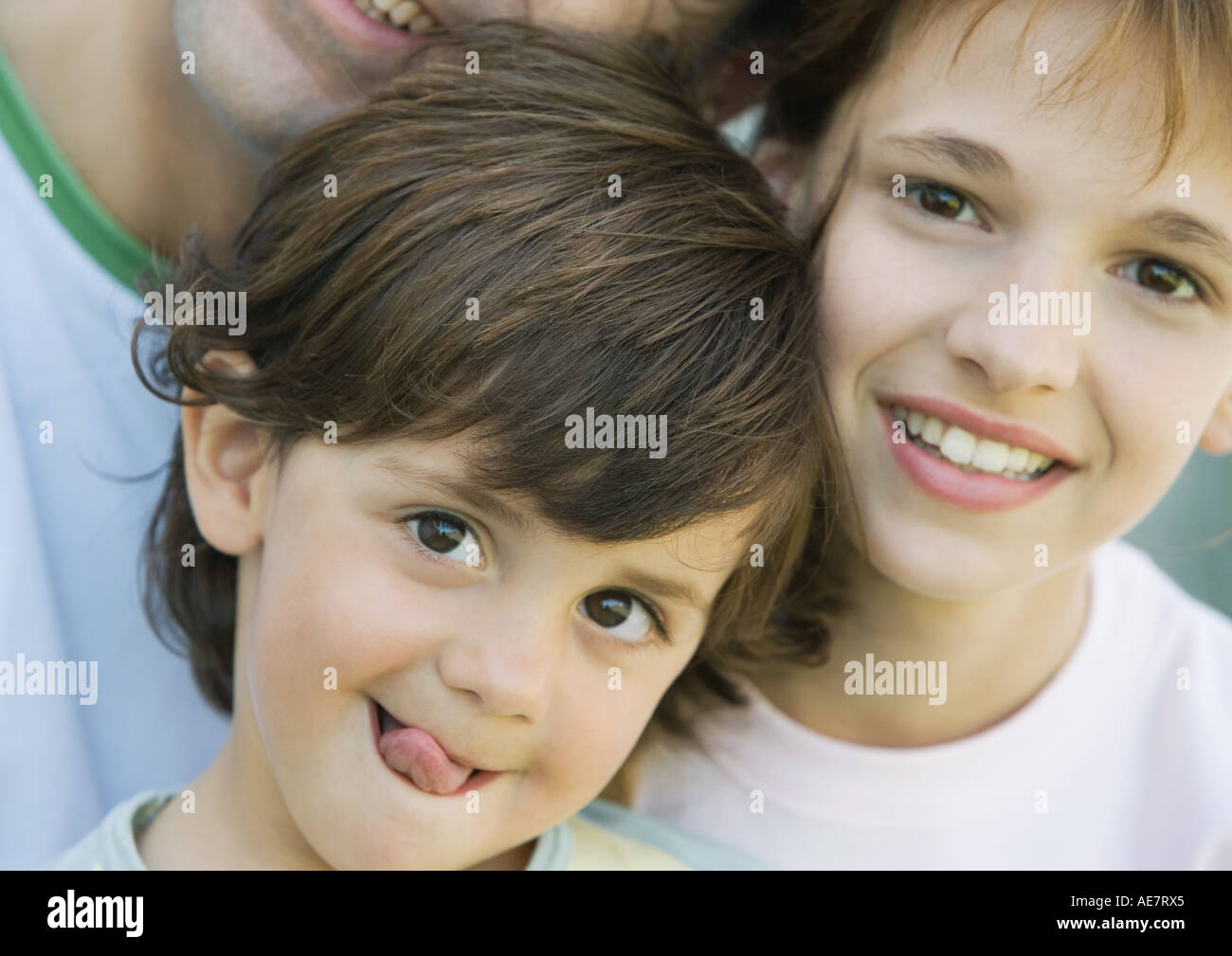 Vater mit zwei Kindern, junge herausragen Zunge, Mädchen und Vater lächelnd, Porträt, extreme Nahaufnahme Stockfoto