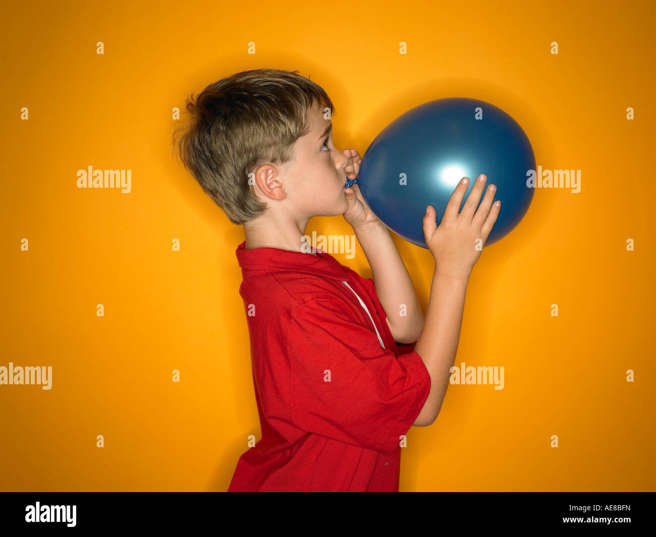 Kind-Seite auf Profil Sprengung einen blauen Ballon Stockfoto