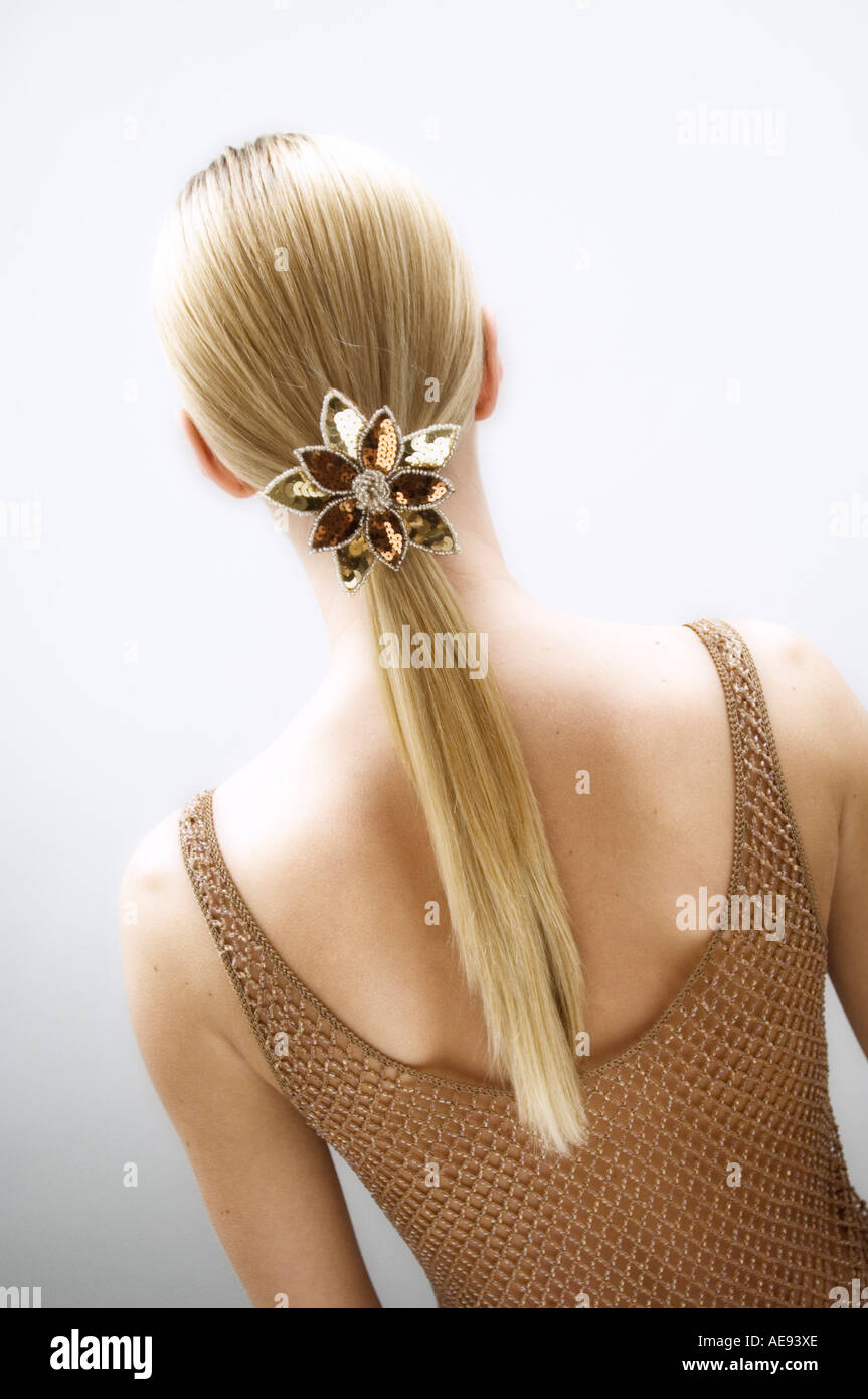 Junge Frau, Ansicht von hinten, Folie in ihr blondes Haar (Studio) Stockfoto