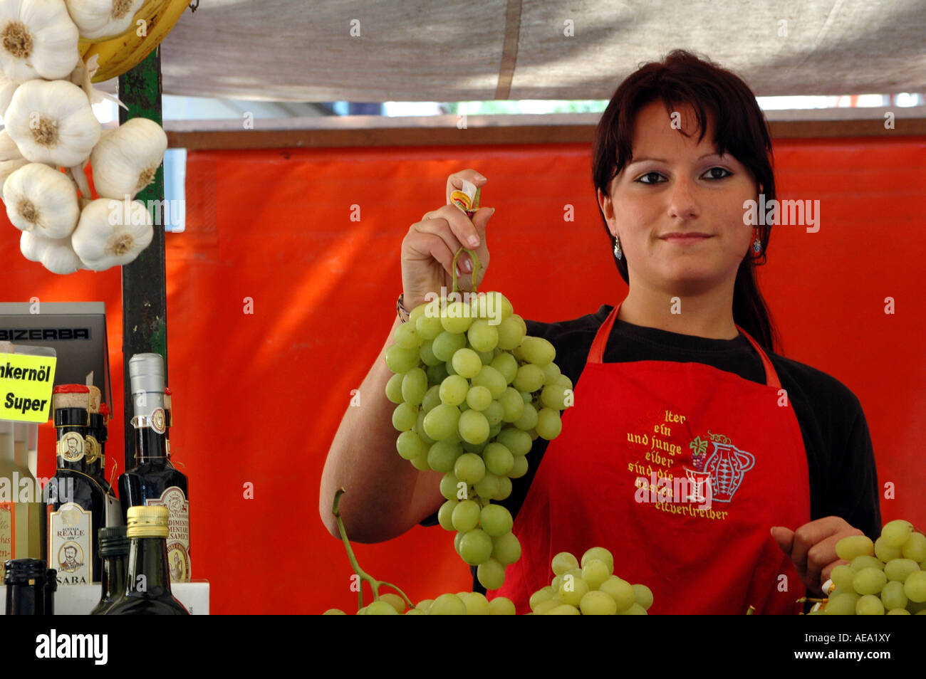 Eine weibliche Anbieter halten Weintraube auf dem Obst und Gemüse Markt in Meran, Italien Stockfoto
