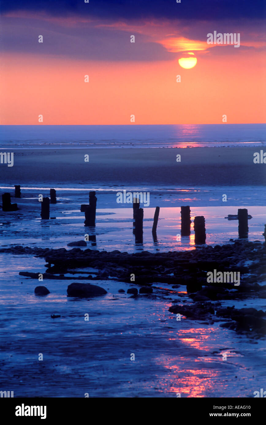 Sonnenuntergang blass weichen zarten über Strand und Buhnen leisten Wasser Reflexionen Blackpool England uk Stockfoto