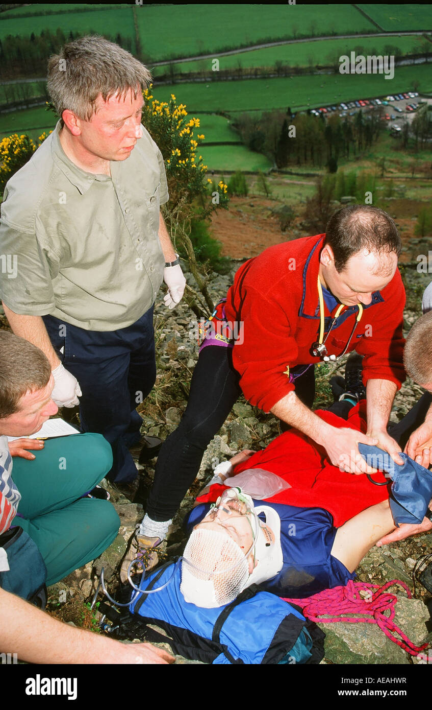 Mountain Rescue Team-Mitglieder behandeln einen Schwerverletzten Kletterer im Langdale, Lake District, Großbritannien Stockfoto
