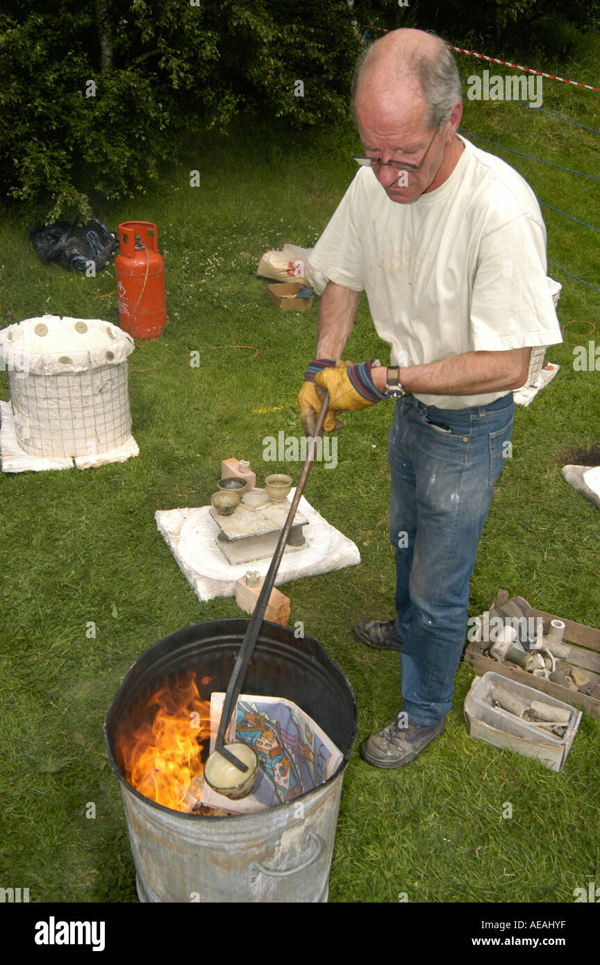 Mittleren Alter Mann potter vorbereiten, Raku-Brand eine Keramik Topf in Aberystwyth Kunst Zentrum Mitte des Sommers Wahnsinn Familienspaß Tag Stockfoto