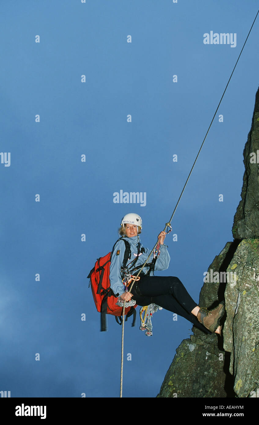 Eine weibliche Mountain Rescue Team Meber Abseilen ein Fels im Lake District, UK Stockfoto