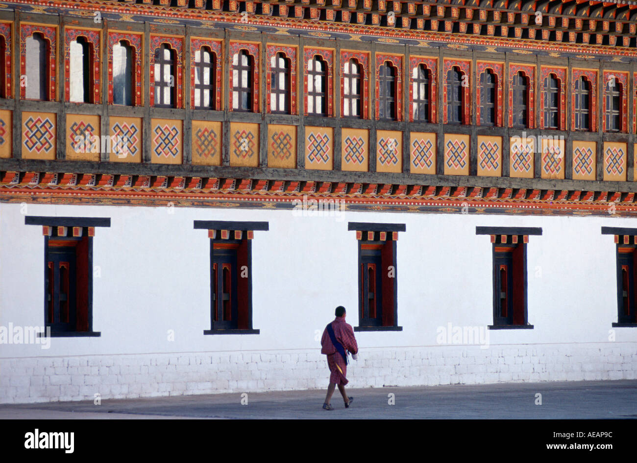 Ein Mann zu Fuß neben der Tashichho Dzong Heimat der Regierung Königspalast und religiöses Zentrum in Thimpu, Bhutan Stockfoto
