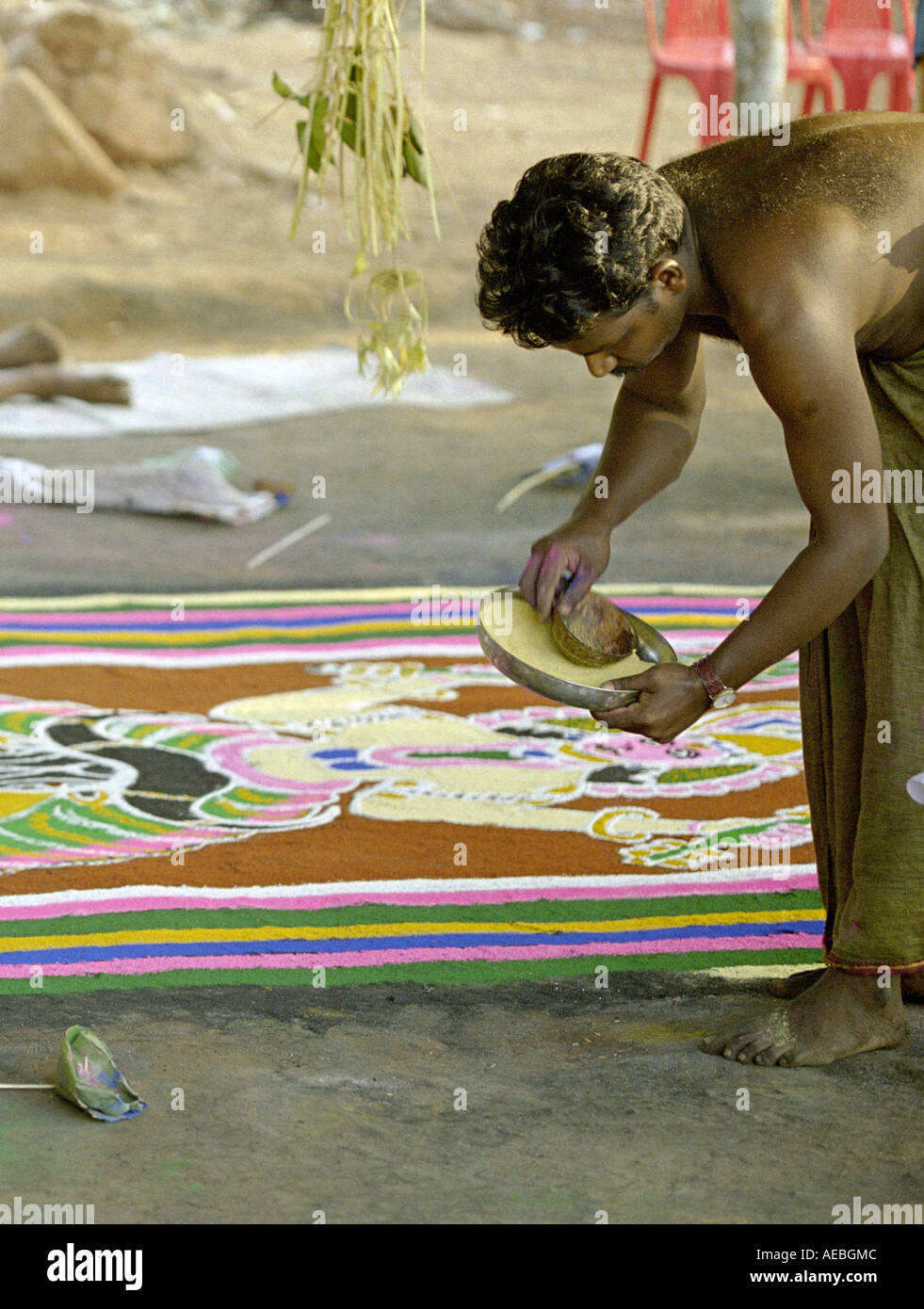 Zwei Künstler Zeichnung Kalam, eine Bodengestaltung während eines Rituals in einem Tempel in Kerala, Indien Stockfoto