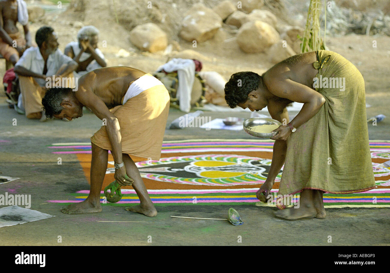 Zwei Künstler Zeichnung Kalam, eine Bodengestaltung während eines Rituals in einem Tempel in Kerala, Indien Stockfoto