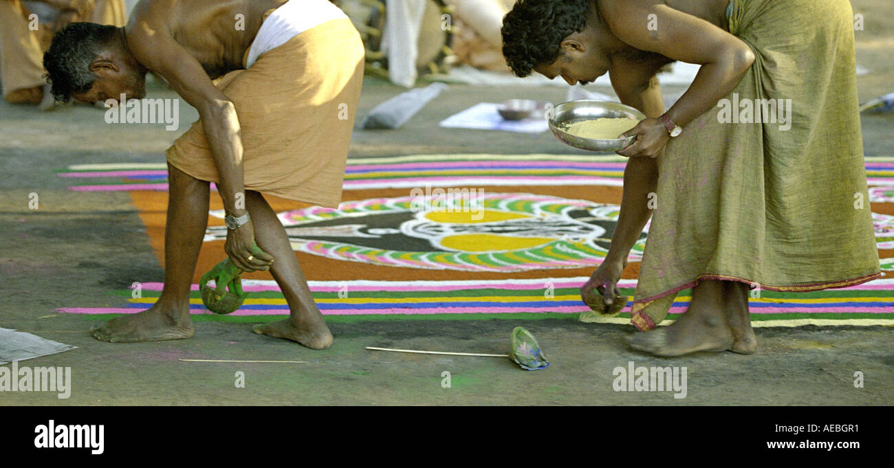 Zwei Künstler zeichnen einen Kalam während eines Rituals in einem Tempel von Kerala, Indien Stockfoto