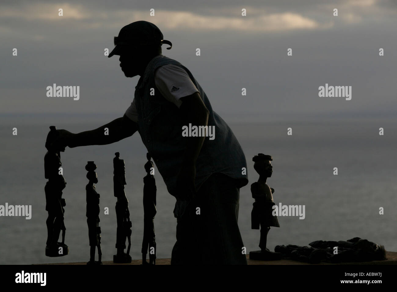 Eine informelle Händler ordnet Holz afrikanische Kuriositäten an Touristen auf der Küstenstraße nach Hout Bay, Kapstadt, Südafrika verkauft. Stockfoto