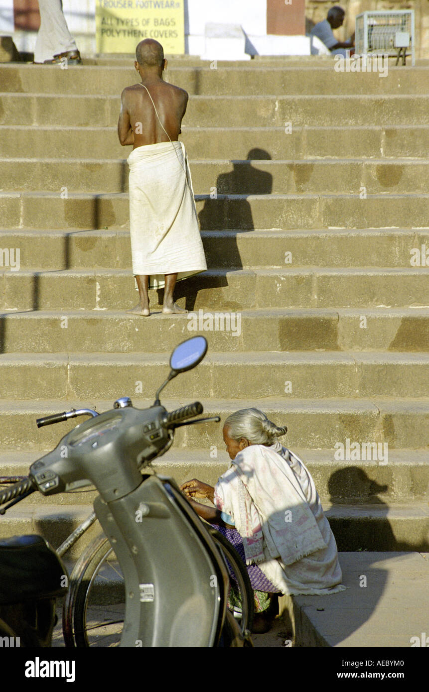 Konzeptbild eines alten Mannes noch auf Schritte mit einem geparkten Motorrad und eine sitzende alte Dame stehend Stockfoto