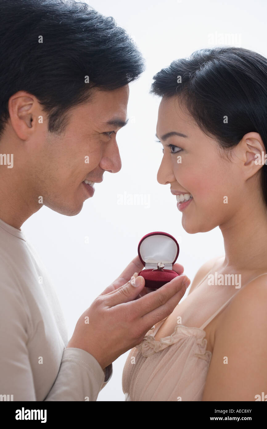 Asiatischer Mann schlägt vor, Freundin Stockfoto