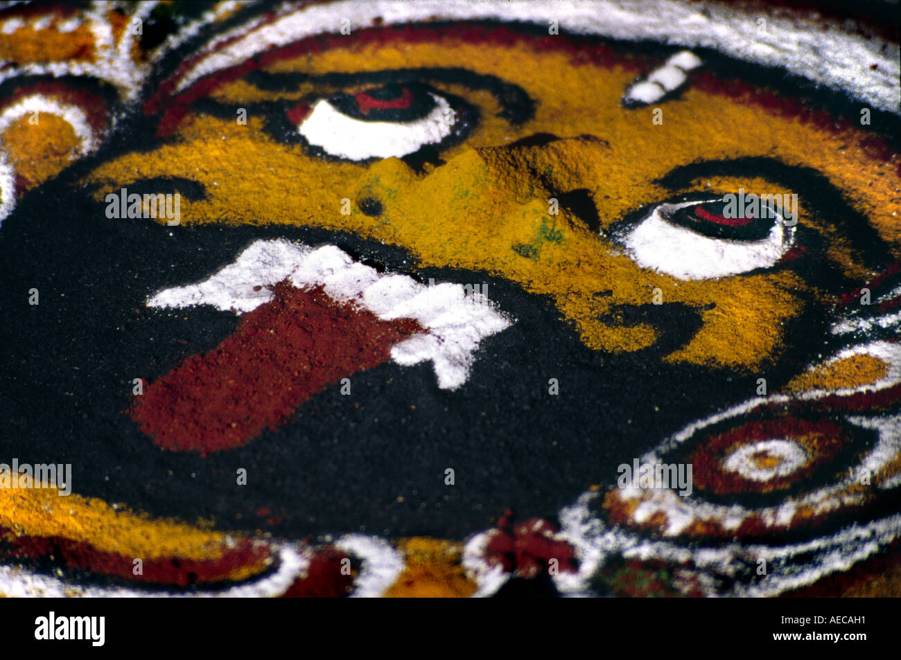Nahaufnahme des Gesichts Gottes ein Dämon gezeichnet in der Kalam von Kerala, Indien Stockfoto