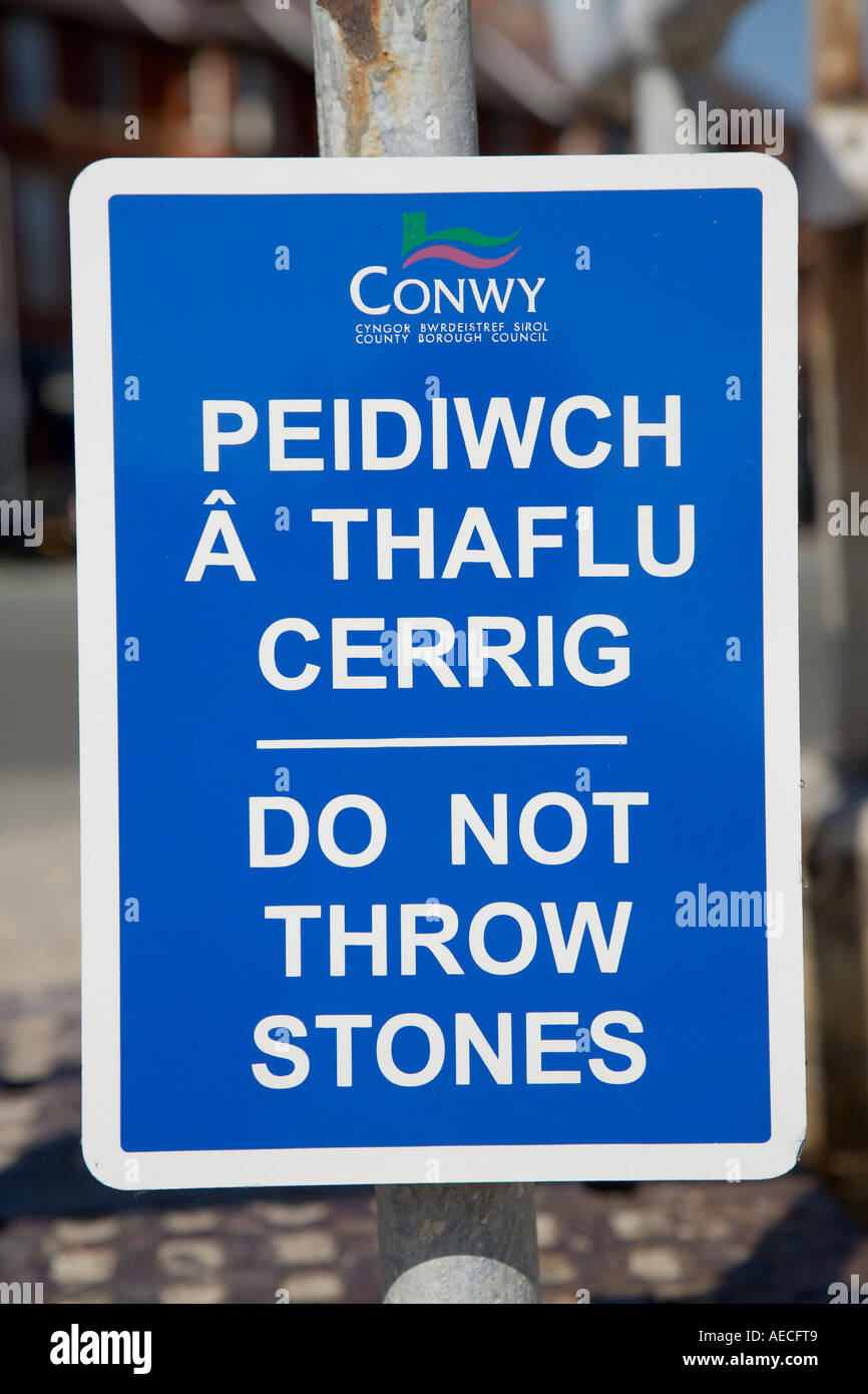 Werfen Sie nicht Steinen zweisprachige zweisprachige Waliser Englisch Warnschild am Strand von Rhos auf Meer Nord Wales UK Stockfoto
