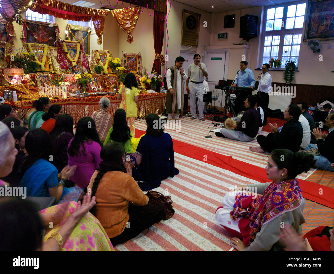 Hindu Zentrum Wimbledon England Navratri Musiker und Publikum mit Bühne dekoriert mit Hindu-Götter und Angebote Stockfoto