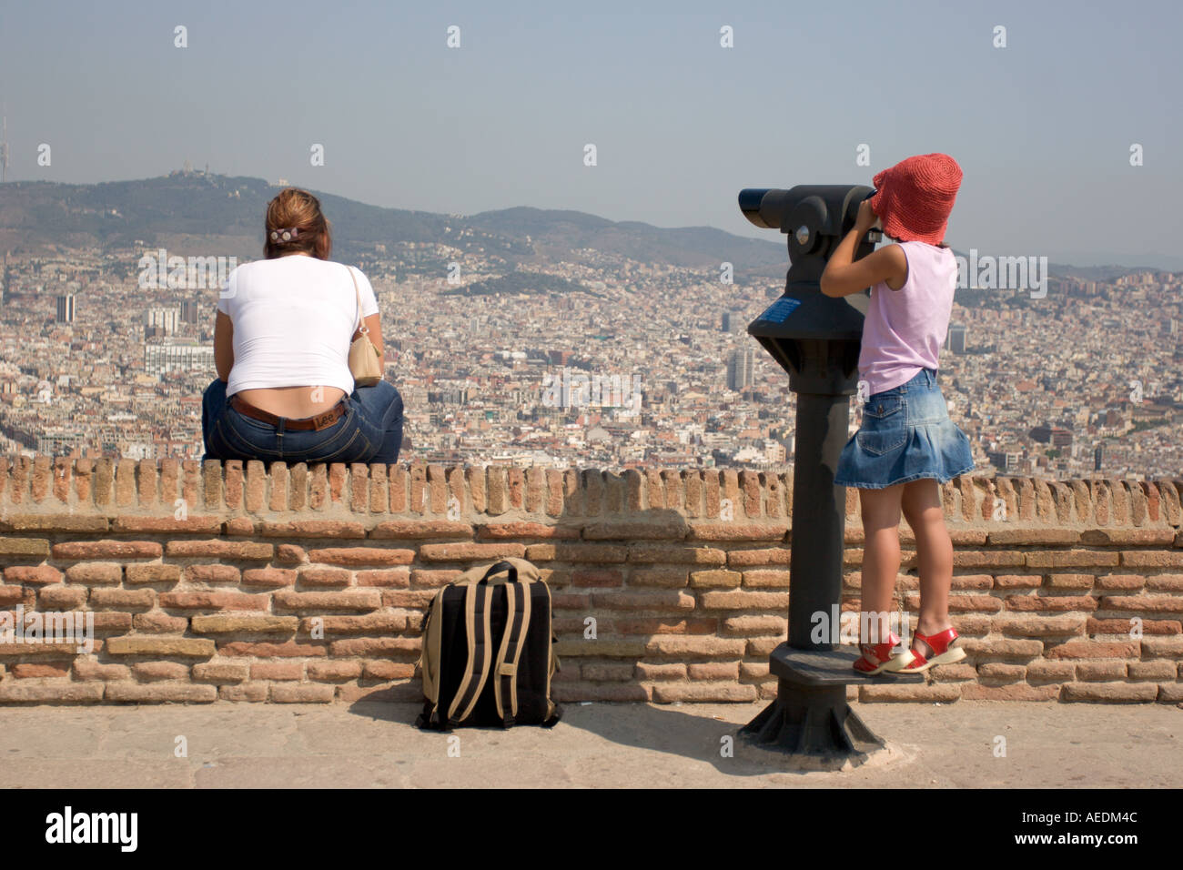 Mutter und Kind mit rotem Hut genießen einen Panoramablick auf Barcelona von Mirador del Alcalde. Stockfoto