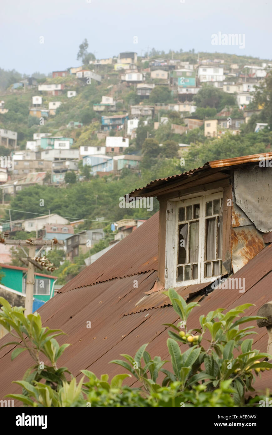 Bunte Häuser auf einem Hügel über einem verrosteten Blechdach in Valparaiso, Chile. Stockfoto