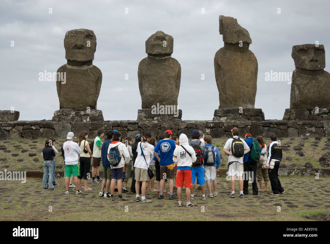 Touristen versammeln sich vor dem geschnitzten Steinfiguren oder Moais am Ahu Tahai in der Nähe von Hanga Roa auf der Osterinsel. Stockfoto
