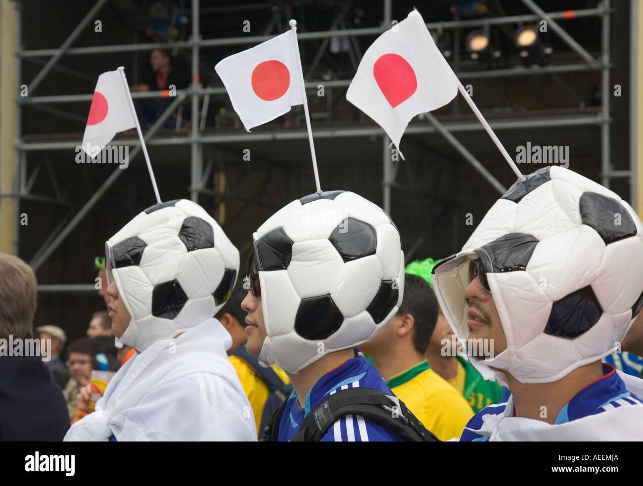 Drei japanische Fußball-Fans tragen Hüte, die aussehen wie Fußbälle in ein Fußball-Welt-Cup-public-Viewing-Event in Dortmund Stockfoto