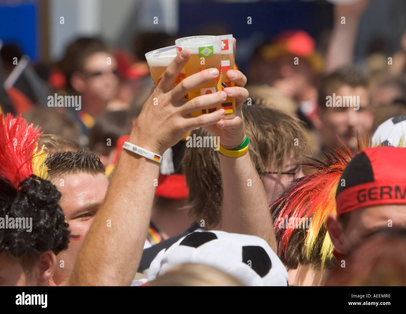 Ein Fußball-Fan, tragen einige Tassen gefüllt mit Bier durch die Menge während der WM Spiel Deutschland gegen Schweden (2:0) Stockfoto