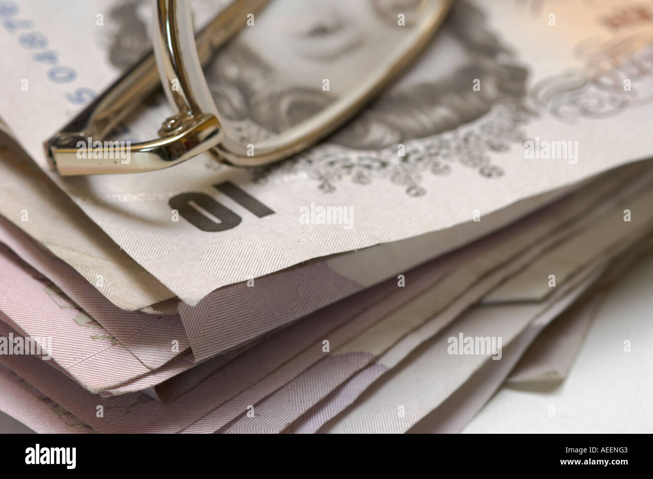 Stapel von verwendet britische Banknoten gemischte Konfessionen mit Metall gerahmte Brille an der Spitze Stockfoto
